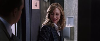 Movie still from “The Departed” (2006), directed by Martin Scorsese – A woman in a business suit smiling for the camera; Close Up shot, Over the shoulder angle