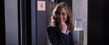 Movie still from “The Departed” (2006), directed by Martin Scorsese – A woman in a business suit smiling for the camera; Close Up shot, Over the shoulder angle