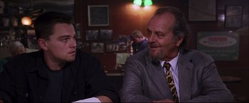 Movie still from “The Departed” (2006), directed by Martin Scorsese – Two men sitting at a table in front of each other; Medium shot, Over the shoulder angle
