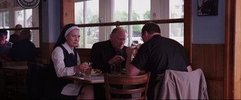 Movie still from “The Departed” (2006), directed by Martin Scorsese – A group of people sitting at a table in front of a window; Medium shot, Over the shoulder angle