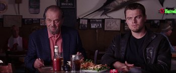 Movie still from “The Departed” (2006), directed by Martin Scorsese – Two people sitting at a table with a plate of food; Medium shot, Over the shoulder angle