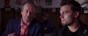 Movie still from “The Departed” (2006), directed by Martin Scorsese – Two men are sitting at a table in front of a woman; Close Up shot, Over the shoulder angle