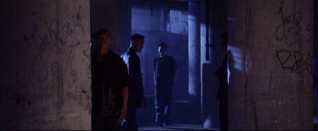 Movie still from “The Departed” (2006), directed by Martin Scorsese – A group of people standing in a dark room; Wide shot, Low angle