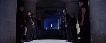 Movie still from “The Departed” (2006), directed by Martin Scorsese – A group of people standing around in a room at night; Wide shot, Low angle