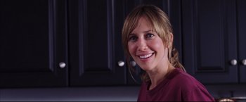 Movie still from “The Departed” (2006), directed by Martin Scorsese – A woman smiling for the camera in front of a cabinet; Close Up shot, Over the shoulder angle
