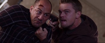 Movie still from “The Departed” (2006), directed by Martin Scorsese – Two men are holding a cell phone in their hands; Close Up shot, Over the shoulder angle