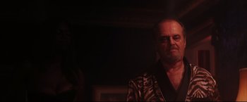 Movie still from “The Departed” (2006), directed by Martin Scorsese – A man in a black and white jacket is standing in a dark room; Close Up shot, Low angle