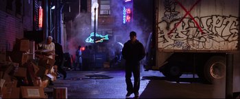 Movie still from “The Departed” (2006), directed by Martin Scorsese – A man standing on the side of the street at night; Wide shot, Low angle