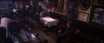 Movie still from “The Departed” (2006), directed by Martin Scorsese – Three people are sitting at a table in a restaurant; Wide shot, High angle