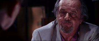 Movie still from “The Departed” (2006), directed by Martin Scorsese – An older man wearing a striped jacket looking at the camera; Close Up shot, Over the shoulder angle