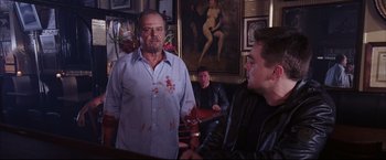 Movie still from “The Departed” (2006), directed by Martin Scorsese – A man with blood all over his face is standing in front of two other men; Medium shot, Over the shoulder angle