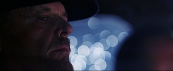 Movie still from “The Departed” (2006), directed by Martin Scorsese – A man's face with lights in the background; Extreme Close Up shot, Low angle