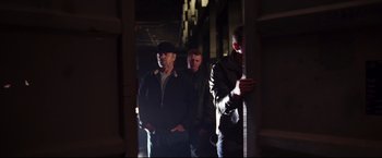 Movie still from “The Departed” (2006), directed by Martin Scorsese – A group of men standing next to each other in the dark; Medium shot, Low angle