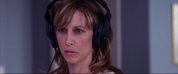 Movie still from “The Departed” (2006), directed by Martin Scorsese – A person wearing headphones and looking sad; Close Up shot, Over the shoulder angle