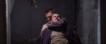Movie still from “The Departed” (2006), directed by Martin Scorsese – A man holding another man with a knife in his hand; Close Up shot, Low angle