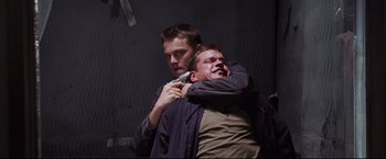 Movie still from “The Departed” (2006), directed by Martin Scorsese – A man holding another man's face while holding a remote; Close Up shot, Low angle