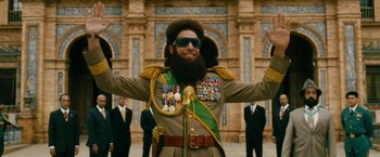 Movie still from “The Dictator” (2012), directed by Larry Charles – A man in a military uniform with a beard and sunglasses; Medium shot, Low angle