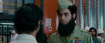 Movie still from “The Dictator” (2012), directed by Larry Charles – A man with a long beard and a hat on; Close Up shot, Over the shoulder angle