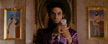 Movie still from “The Dictator” (2012), directed by Larry Charles – A man in a purple jacket holding a white phone; Close Up shot, Low angle