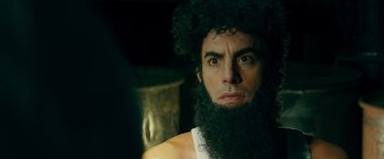 Movie still from “The Dictator” (2012), directed by Larry Charles – A man with a long beard and a mustache; Close Up shot, Over the shoulder angle