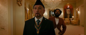 Movie still from “The Dictator” (2012), directed by Larry Charles – A man in a suit and a man with a beard; Medium shot, Over the shoulder angle