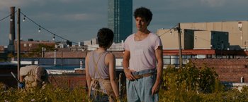 Movie still from “The Dictator” (2012), directed by Larry Charles – A man and a woman standing next to each other on top of a building; Medium shot, Over the shoulder angle