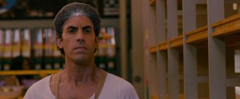 Movie still from “The Dictator” (2012), directed by Larry Charles – A person wearing a hat; Close Up shot, Over the shoulder angle