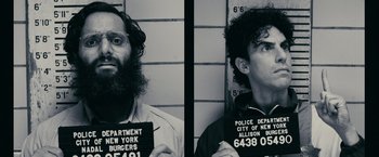 Movie still from “The Dictator” (2012), directed by Larry Charles – Two men are posing for a photo in a police station; Close Up shot, Overhead angle