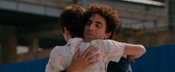 Movie still from “The Dictator” (2012), directed by Larry Charles – A man hugging another man with his eyes closed; Close Up shot, Over the shoulder angle