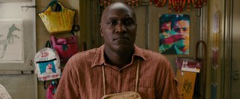 Movie still from “The Dictator” (2012), directed by Larry Charles – A man wearing a brown shirt and a brown bag; Close Up shot, Over the shoulder angle