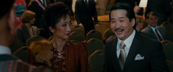 Movie still from “The Dictator” (2012), directed by Larry Charles – A man and a woman sitting next to each other; Medium shot, Over the shoulder angle