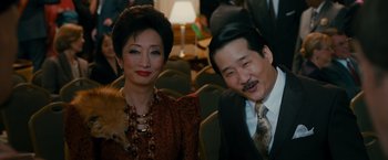 Movie still from “The Dictator” (2012), directed by Larry Charles – A man and a woman sitting next to each other; Medium shot, High angle