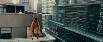 Movie still from “The Dictator” (2012), directed by Larry Charles – A woman in a long coat is hanging on a wire; Extreme Wide shot, Overhead angle