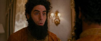 Movie still from “The Dictator” (2012), directed by Larry Charles – A man with long hair and a long beard; Close Up shot, Over the shoulder angle