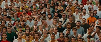 Movie still from “The Dictator” (2012), directed by Larry Charles – A large group of men standing together in a crowd; Extreme Wide shot, High angle