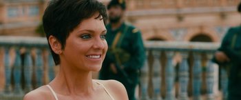 Movie still from “The Dictator” (2012), directed by Larry Charles – A woman smiles while standing in front of a soldier; Close Up shot, Over the shoulder angle