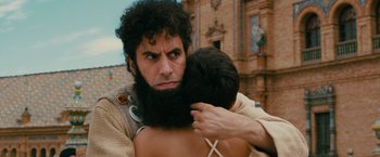 Movie still from “The Dictator” (2012), directed by Larry Charles – A man with a beard hugging a woman; Close Up shot, Over the shoulder angle