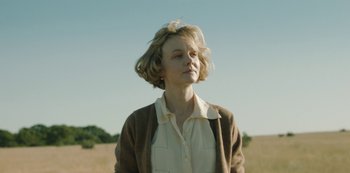 Movie still from “The Dig” (2021), directed by Simon Stone – A woman with her eyes closed standing in a field; Medium shot, Low angle
