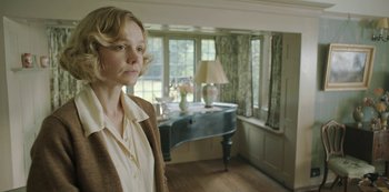 Movie still from “The Dig” (2021), directed by Simon Stone – A woman standing in front of a desk in a room; Medium shot, Low angle