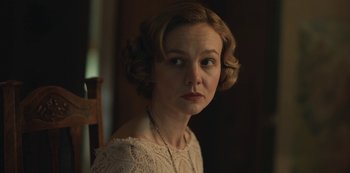 Movie still from “The Dig” (2021), directed by Simon Stone – A woman in a white dress is sitting in a chair; Close Up shot, Over the shoulder angle