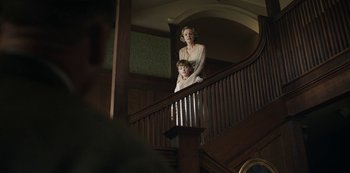 Movie still from “The Dig” (2021), directed by Simon Stone – A woman and a child standing on a staircase; Medium shot, Low angle