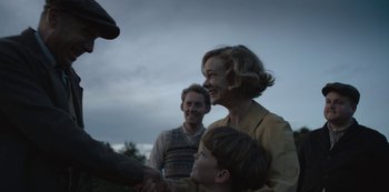 Movie still from “The Dig” (2021), directed by Simon Stone – A woman and a boy shaking hands with a man; Medium shot, Over the shoulder angle
