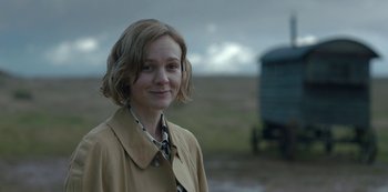 Movie still from “The Dig” (2021), directed by Simon Stone – A woman in a trench coat standing in front of a truck; Close Up shot, Over the shoulder angle