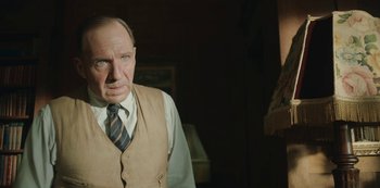 Movie still from “The Dig” (2021), directed by Simon Stone – An older man wearing a vest and a tie; Close Up shot, Low angle