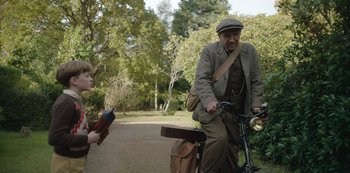 Movie still from “The Dig” (2021), directed by Simon Stone – An older man riding a bicycle with a young woman on the back; Medium shot, Over the shoulder angle