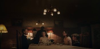 Movie still from “The Dig” (2021), directed by Simon Stone – A group of people sitting at a table in a restaurant; Medium shot, Over the shoulder angle