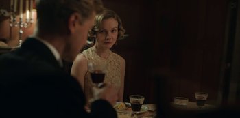 Movie still from “The Dig” (2021), directed by Simon Stone – A man and a woman sitting at a table with a glass of red wine; Medium shot, Over the shoulder angle