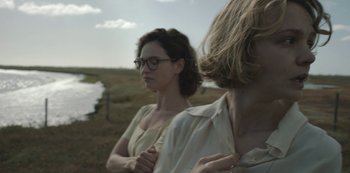 Movie still from “The Dig” (2021), directed by Simon Stone – Two women standing next to each other in a field; Close Up shot, Over the shoulder angle