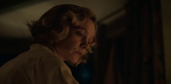 Movie still from “The Dig” (2021), directed by Simon Stone – A woman with blonde curly hair is looking down; Close Up shot, Low angle