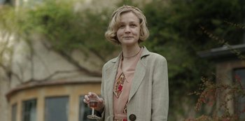 Movie still from “The Dig” (2021), directed by Simon Stone – A woman holding a wine glass in her hand; Medium shot, Over the shoulder angle